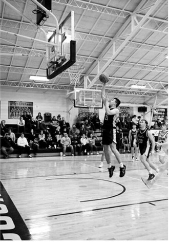 Brody Berg finishes a fast break layup. Photo by Ashley Schafer
