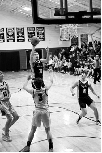 Kade Schafer drives through the lane for a basket. Photo by Ashley Schafer