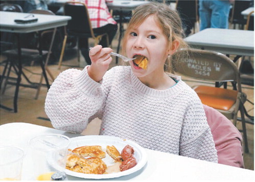 Layken Hansel is all in on breakfast on New Year’s Day at the Masonic Center in Langdon, where Lebanon Lodge #34 held its 8th annual pancake feed. The free will offering collected will benefit the Glen Symons Memorial Masonic Scholarship Fund. Photo by Larry Stokke.