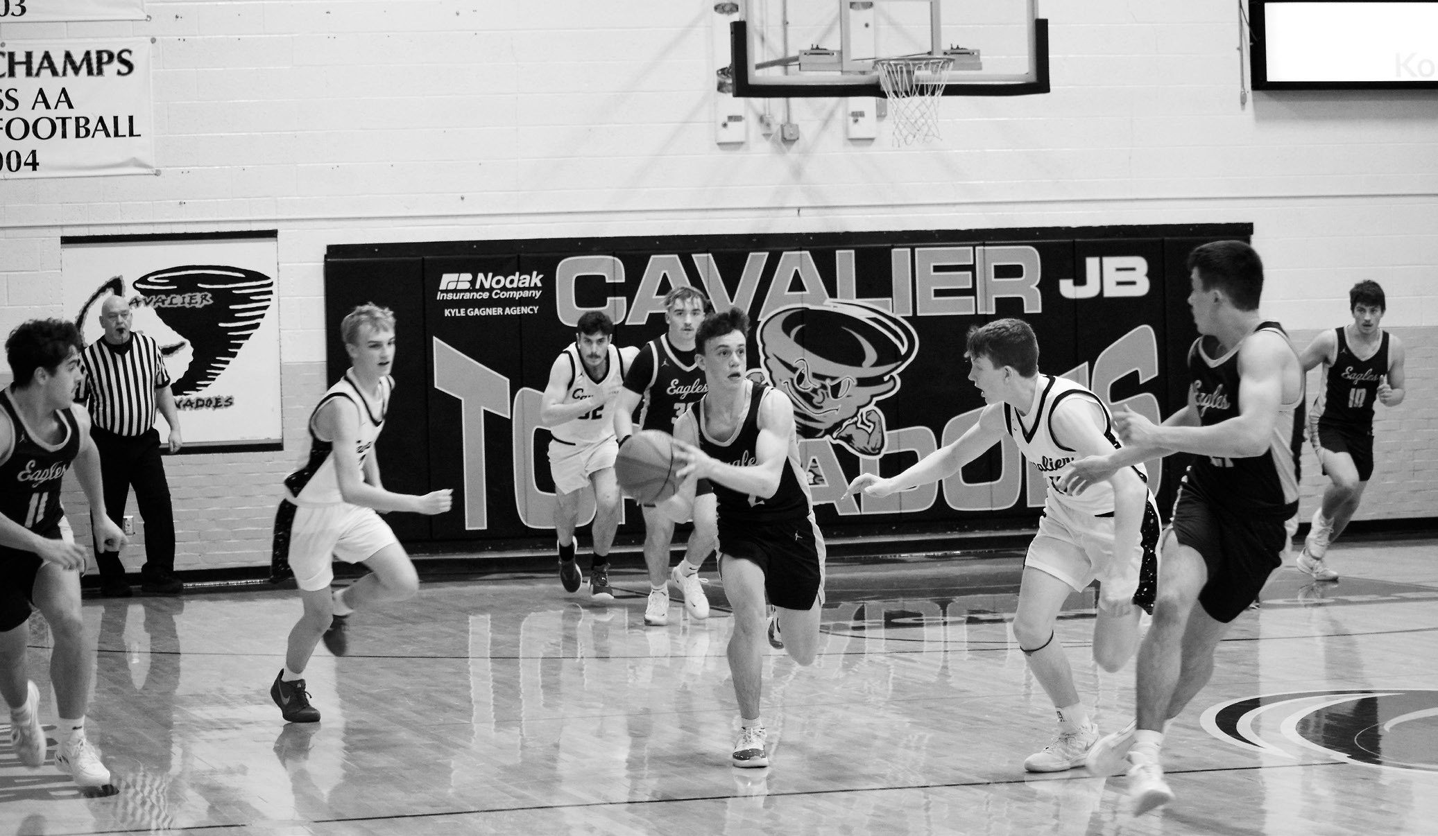 Kaden Moore drives the ball back down the court. Photo by Ashley Schafer.