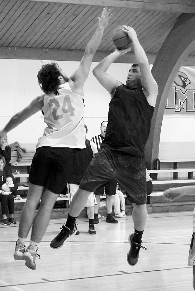 Justin Overby with a hand in his face drops one in the hole for 2-points. Photo by Larry Stokke.