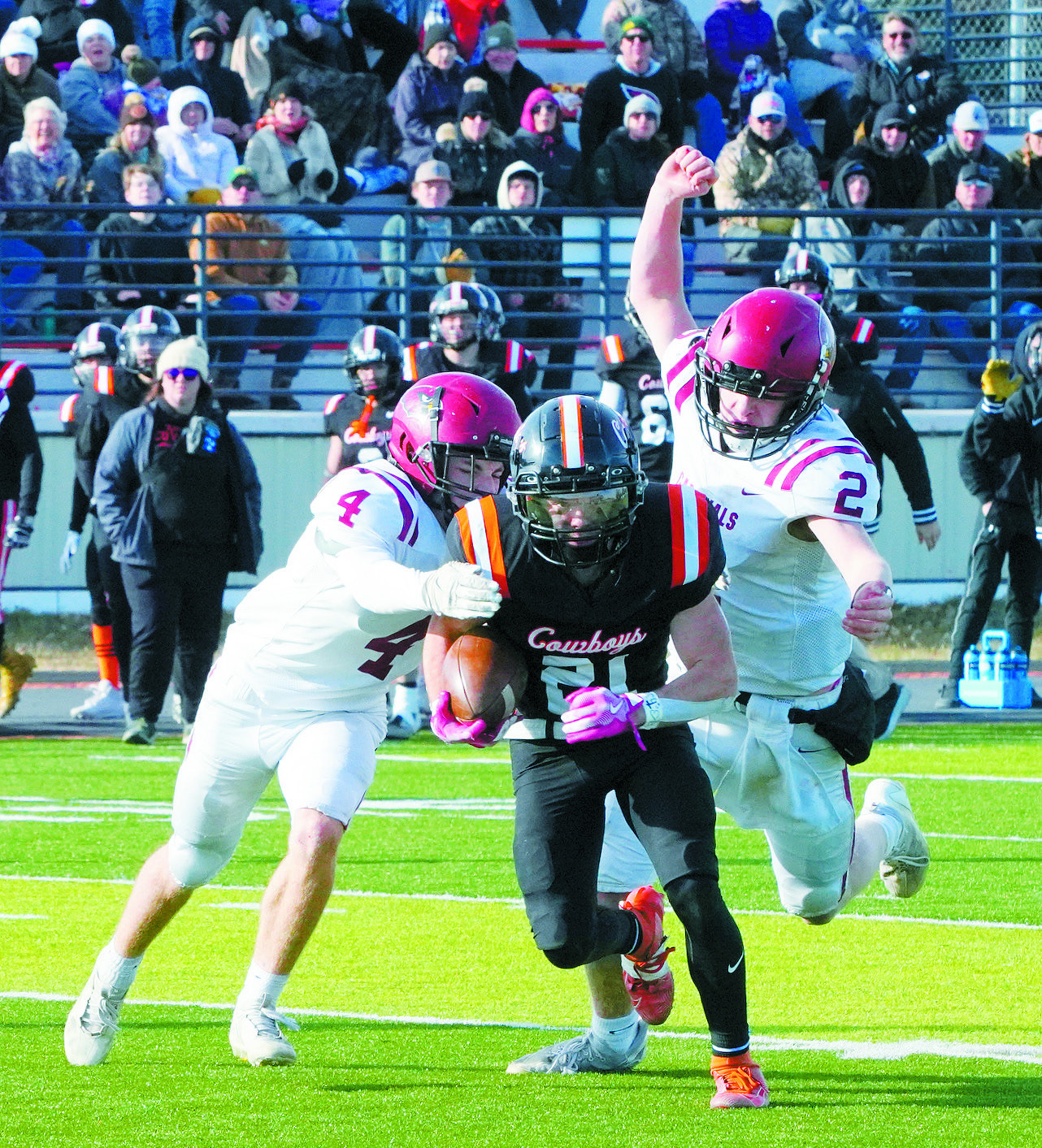Sam Davis and Jax Johnson team up and tackle Michael Dukart for a turnover in downs. Photo by Larry Stokke.