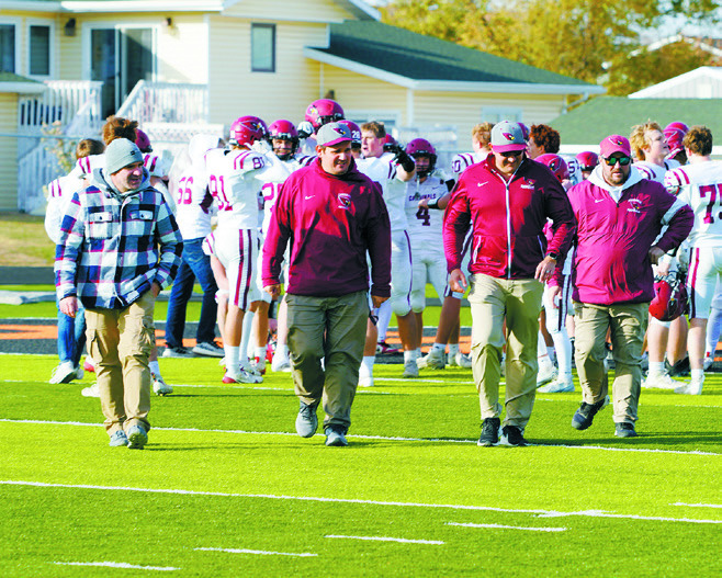 Cardinal coaches walk off the field after a great win against the Killdeer Cowboys. Photo by Larry Stokke.