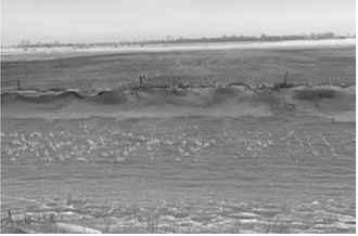 A roadside ditch along Highway 2, about 5 miles west of Grand Forks, North Dakota, full of topsoil from the adjoining field that was tilled in fall on Dec. 19, 2021.