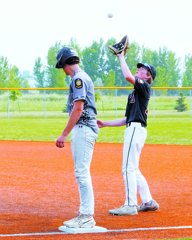 Tyson Gemmill gloves a pop fly by first base against Midway-Minto. Photo by Larry Stokke.