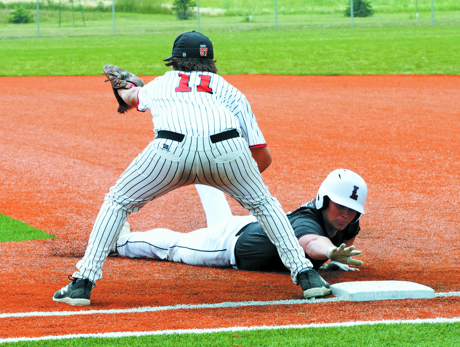 Cole Welsh gets back to first base against Larimore in Park River at Legion Regionals. Photo by Larry Stokke.