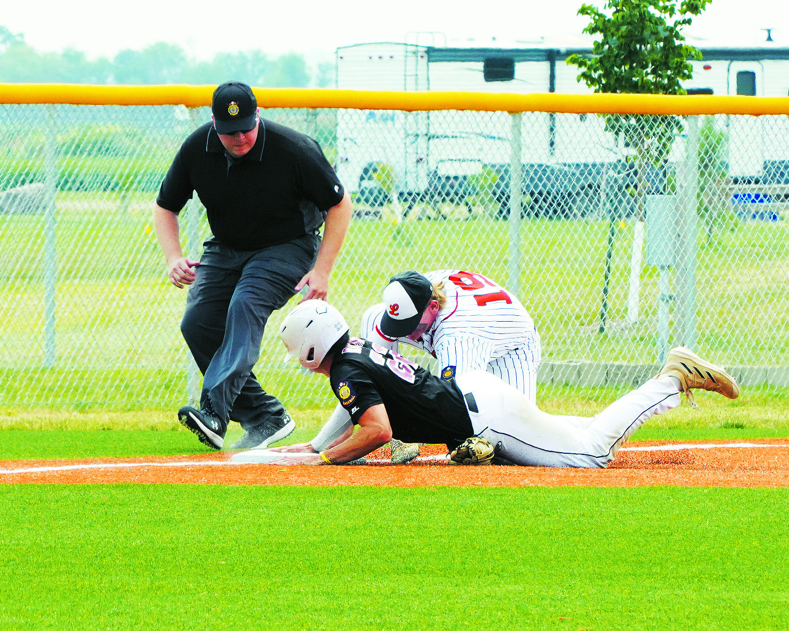 Mason Romfo slides into 3rd base beating the tag-out against Larimore. Photo by Larry Stokke.