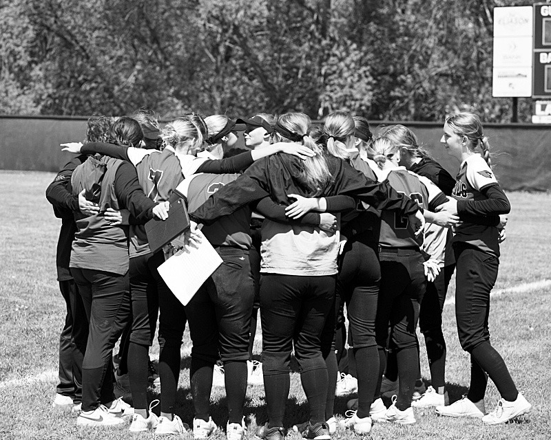 The Lady Cardinals squeeze in for a team hug after the last game of the year. Photo by Larry Stokke.