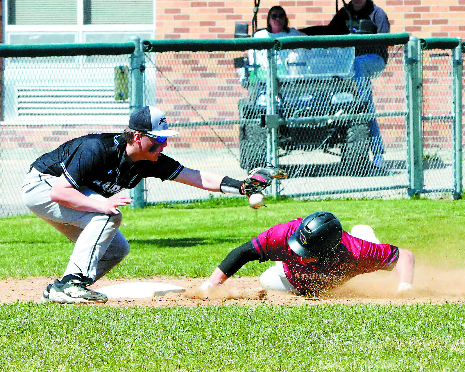 Theo Romfo slides safely onto first base in the win over Nelson County on April 3. Photo by Larry Stokke.