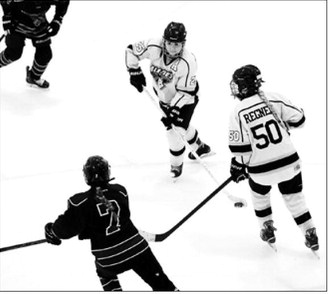 Seniors Kenadee Cluchie and McKenzie Regner work together to control the puck in the 5th place game at the state tournament. Photo by Larry Stokke