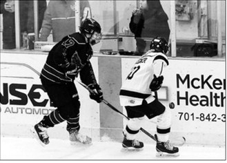 McKenzie Regner fights for the puck in the 5th place game in Watford City on March 8. Photo by Larry Stokke