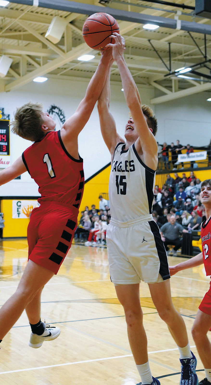 Garret Willits fights for a rebound with a Bearcat. Photo by Larry Stokke.