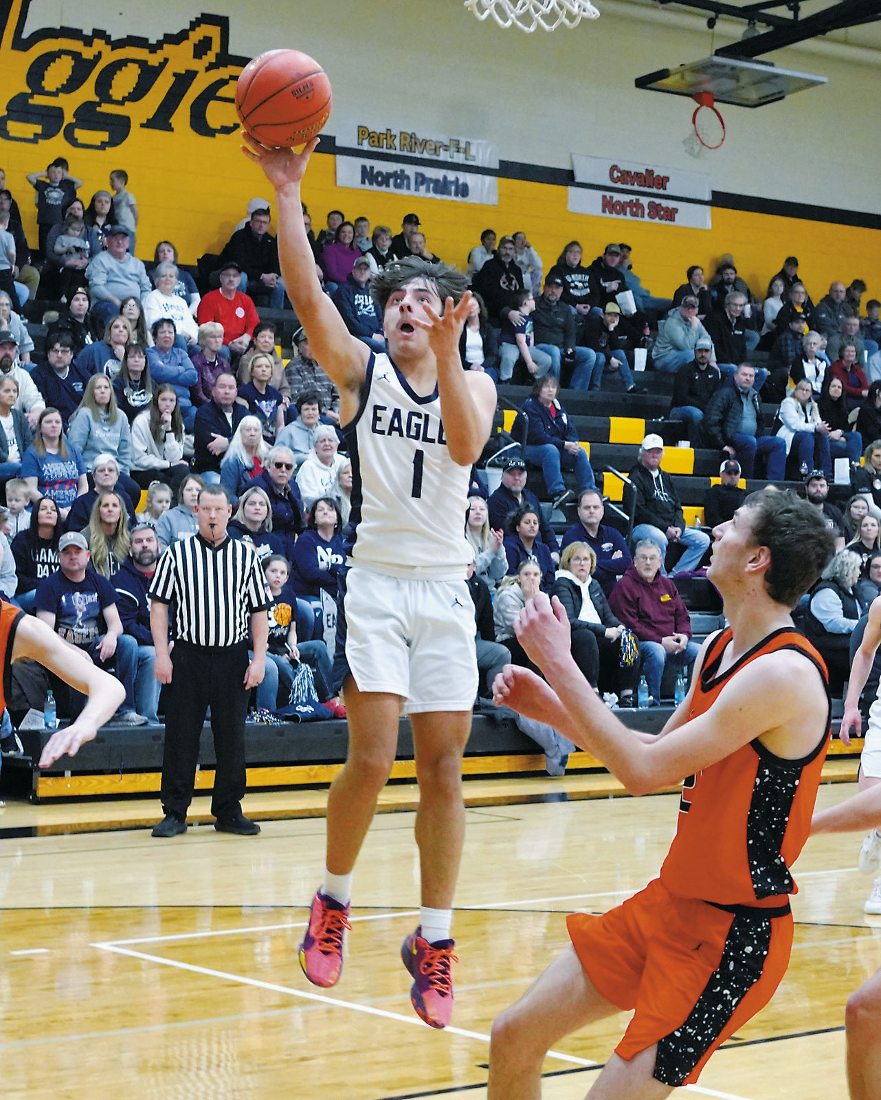 Weston Cosley drives down the lane and drops in a basket during the win over Cavalier. Photo by Larry Stokke.
