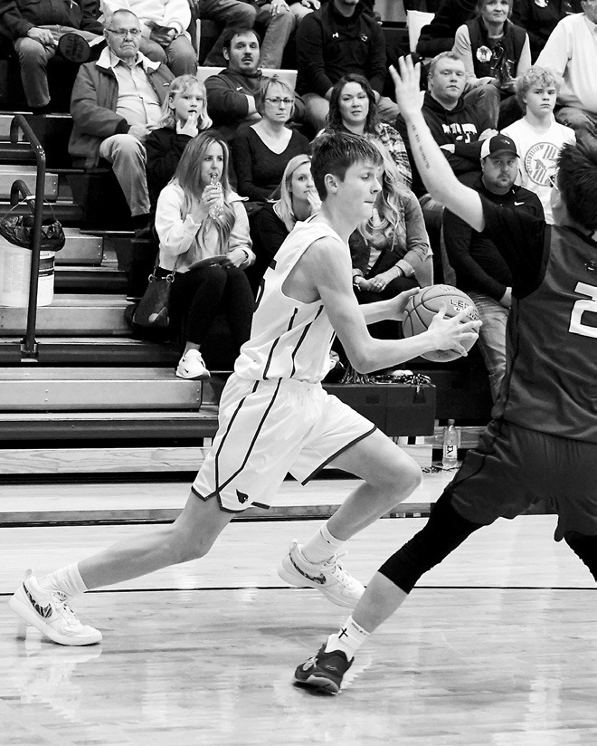 TJ Henderson dribbles around a St. John defender. Photo by Larry Stokke.