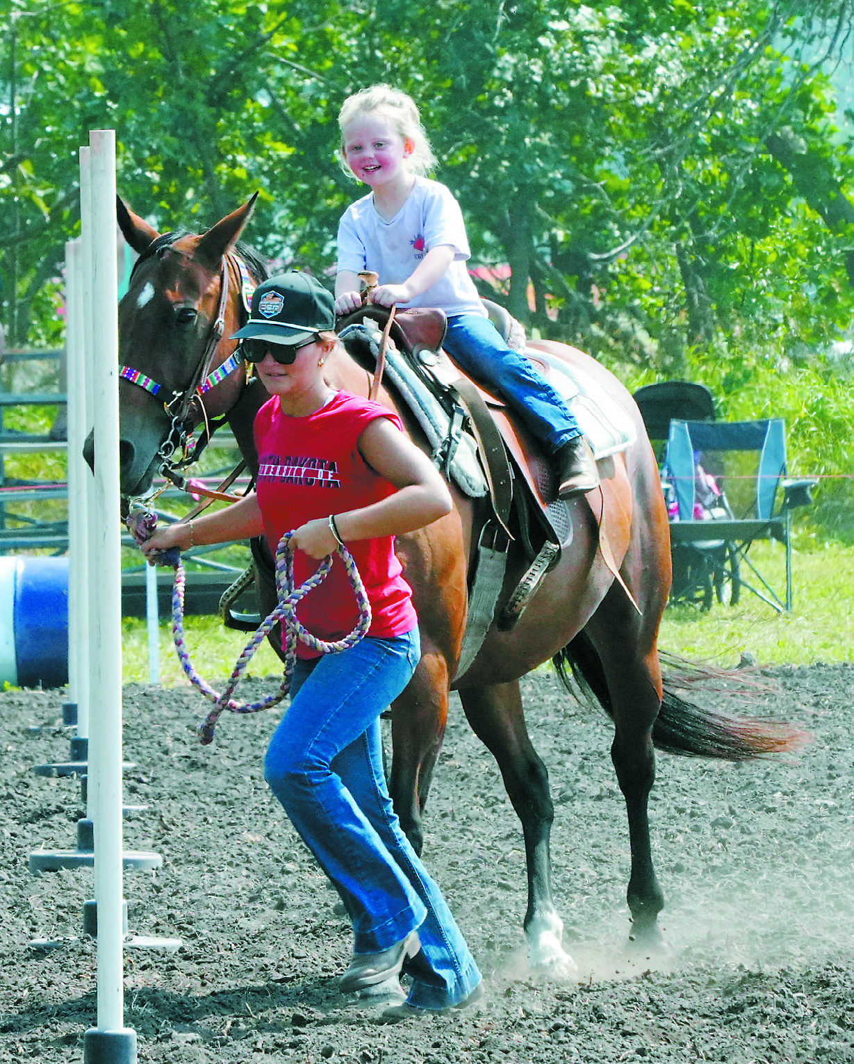 Jacey Nelson leads Winter Moore around the poles in one of the lead line events. Photo by Larry Stokke.