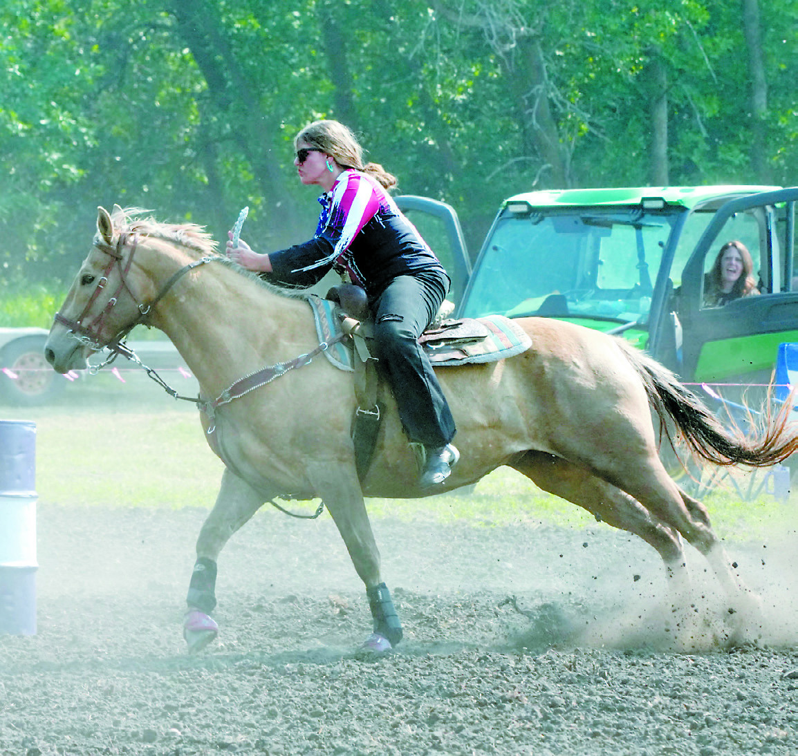 Cheyanne Letexier rounds the first barrel with her mom in the background cheering her on. Photo by Larry Stokke.