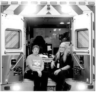 Sheila Beauchamp, left, and Lorraine Gage pose in the back of a Langdon Ambulance Service unit. The two veteran EMTs first earned their National EMS Certification in 1986 and have continued serving the community for four decades. Photo by Larry Stokke