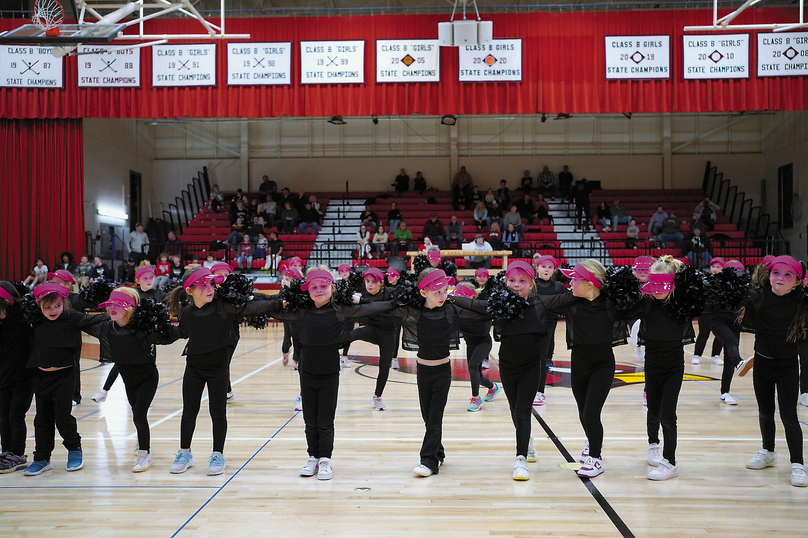 The Pom Pom girls showed off their skills during halftime at a recent basketball game. Sierra Ferdon hopes the high school cheer program will continue to grow as these youngsters do. Photo by Larry Stokke.