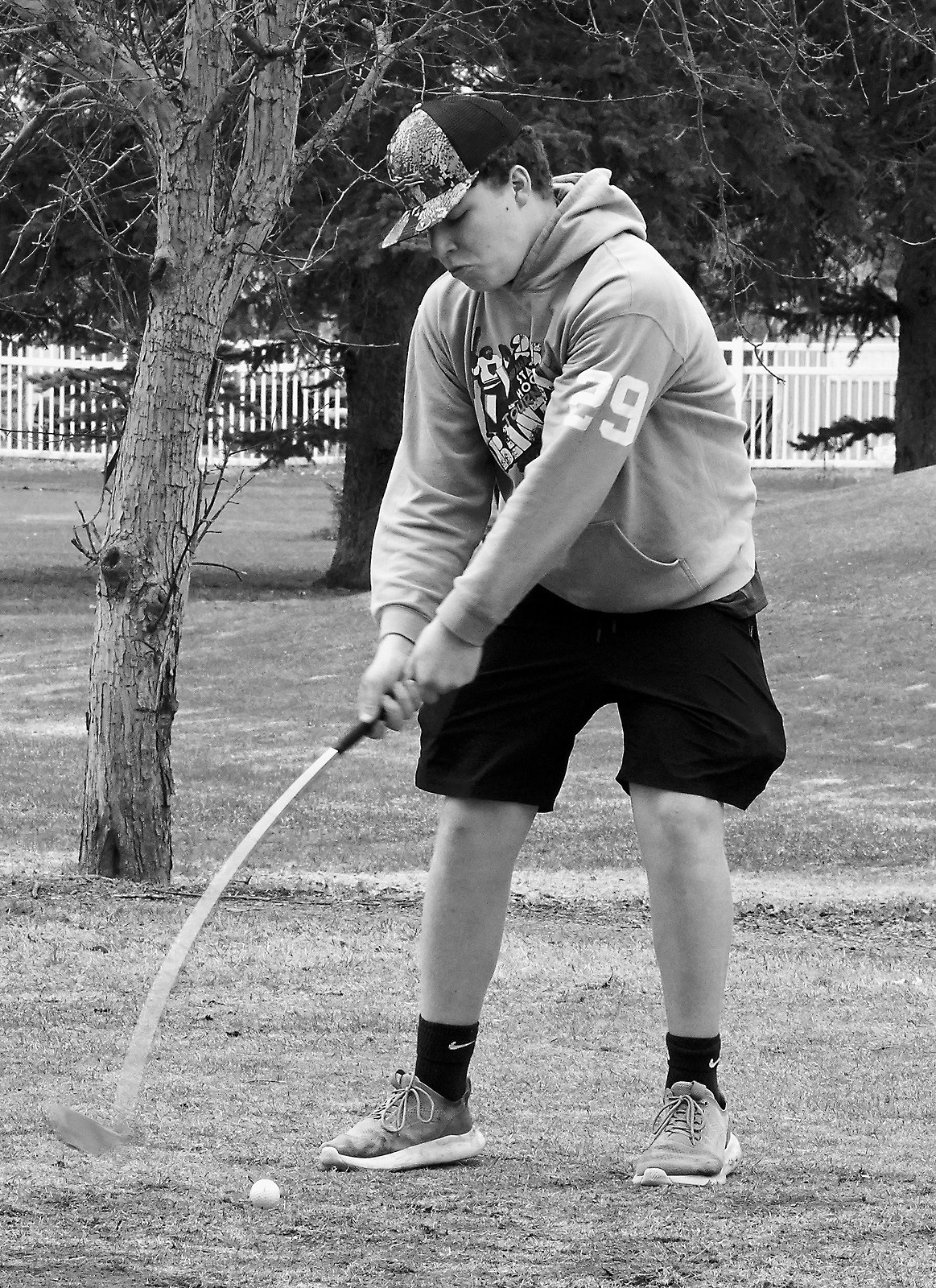 Cardinal Maddux Busse puts a little bend in his club while teeing off in McVille on April 1. Photo by Larry Stokke.