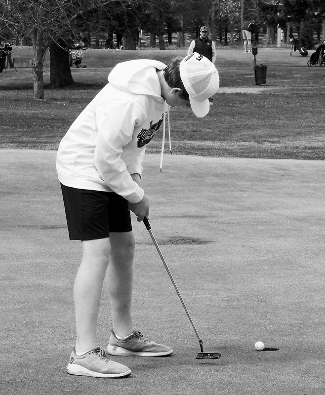 Ryder Moser sinks a putt and finished the meet in 3rd place with a score of 78. Photo by Larry Stokke.