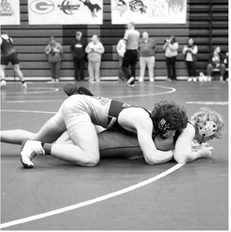 Bryce Carignan won his match by pinning his opponent and is heading to the State Meet. Photo by Larry Stokke