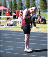 Gavin Trottier braces against the cold before competing at the regional meet in Mayville on May 16 for the Langdon Area/Munich Cardinals. Photo by Ashley Schafer