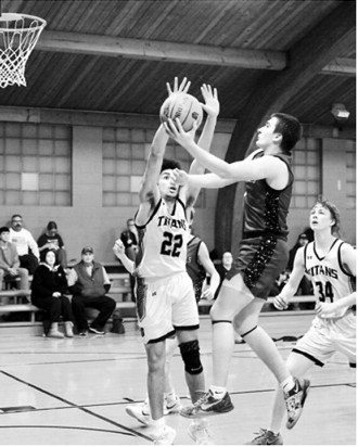 Eastyn Schaefer drives to the basket and finger rolls in a layup when the Cards played the Titans. Photo by Larry Stokke