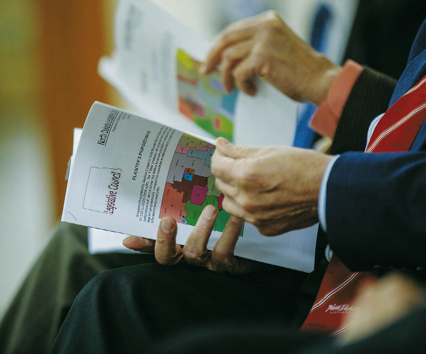 Legislators attending a Redistricting Committee meeting Dec. 13, 2023, look at maps of different proposals. (Photo by Kyle Martin/For the North Dakota Monitor)