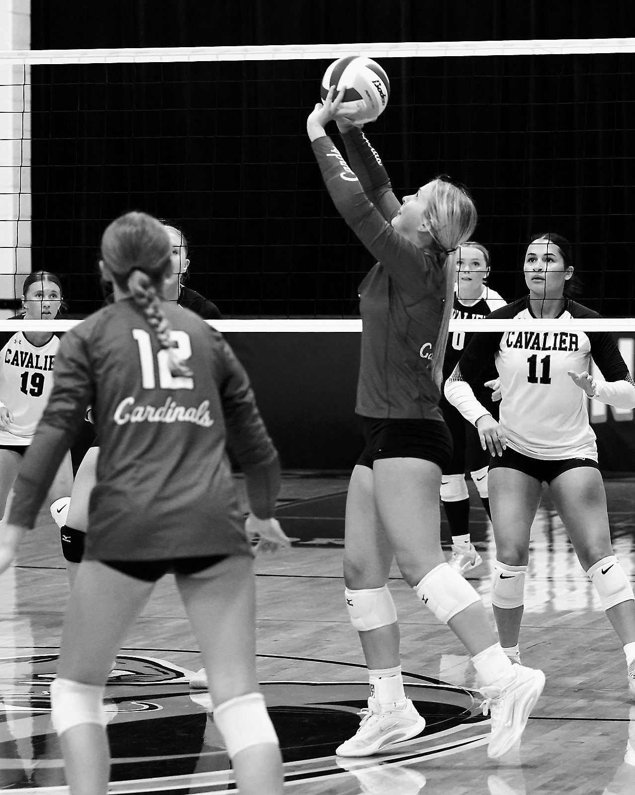 Emma Hall sets the ball to a teammate in the Cards' win over the Cavalier Tornadoes. Photo by Larry Stokke.