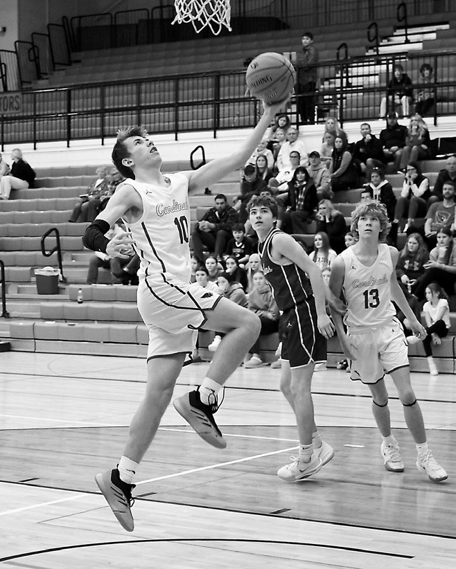 Maddux Stremick with a drive into the lane and a finger roll adds two points to the Cards' score. Photo by Larry Stokke.