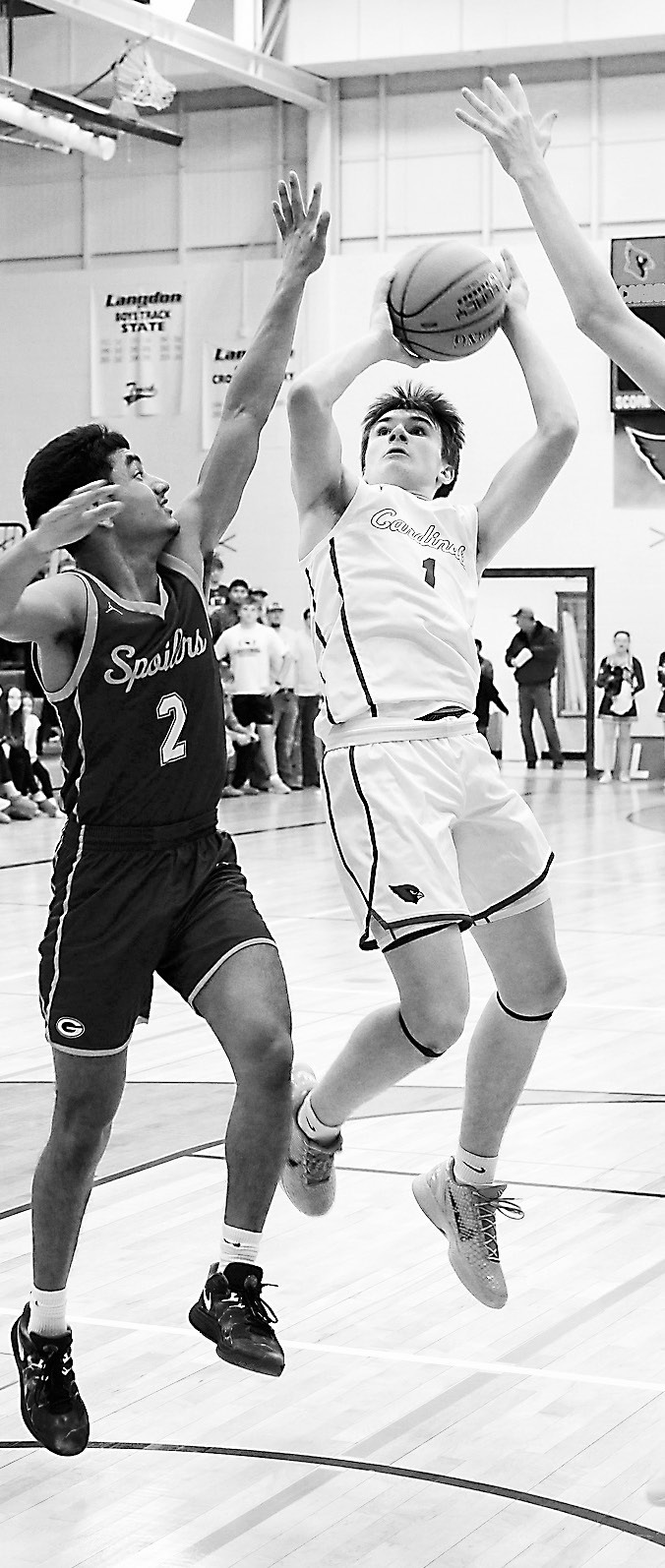 Eastyn Schaefer sinks a basket with two Spoilers defending him, finishing the game with team high 20 points. Photo by Larry Stokke.