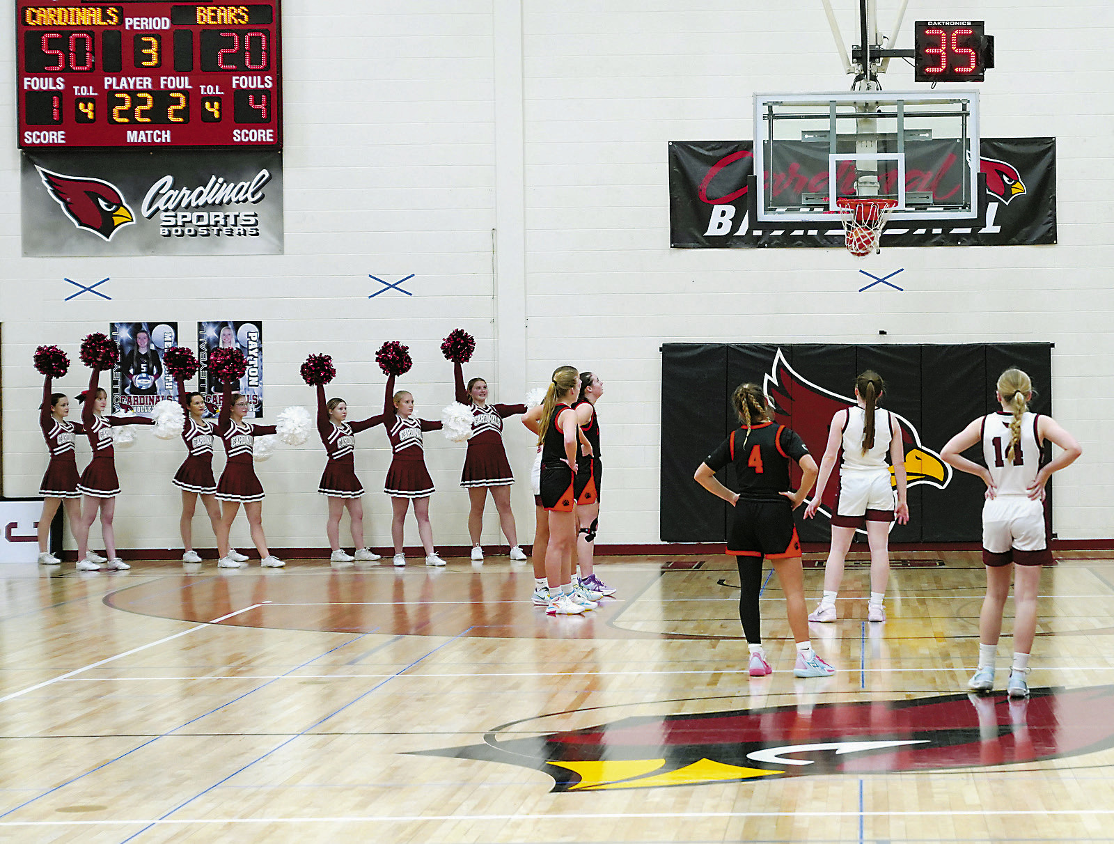 The Cardinals cheerleaders cheer on Merideth Romfo while she drained a free throw in the Cards' win over the Polar Bears. Photo by Larry Stokke.