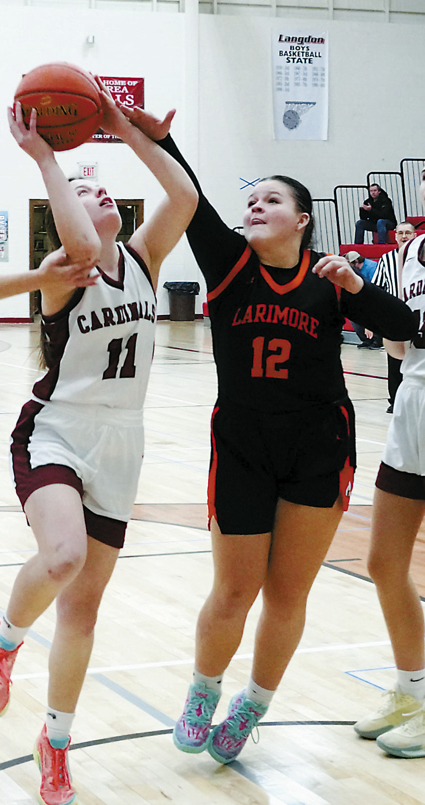 Erika Bakke drives in, makes a layup and adds a free throw for a three point play. Photo by Larry Stokke.