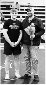 It was Senior Night in Walhalla Feb. 3 and the only Senior this year is Gavin Symington, pictured along with his dad Mel. Gavin received a round of applause for his career as a Grizzly wrestler. Photo by Larry Stokke