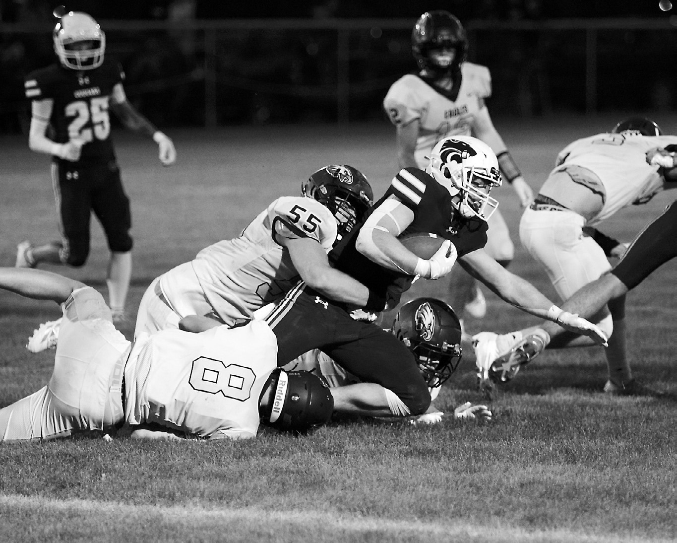 Gavin Symington and Garret Willits along with another Eagle tackle the Cougars’ Layton Olson. Photo by Larry Stokke.