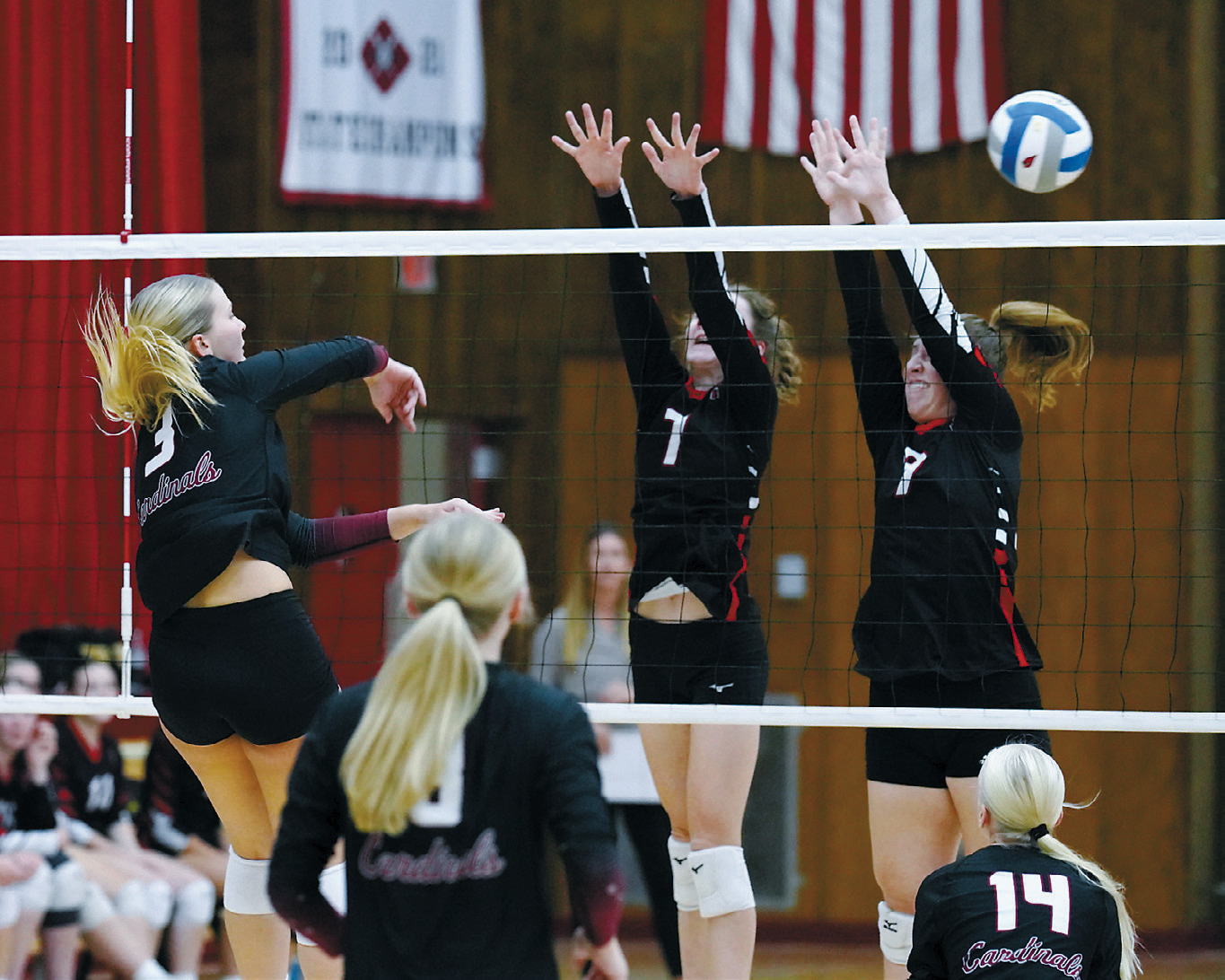 Emma Hall sends one of her kills past two Bearcats. Photo by Larry Stokke.