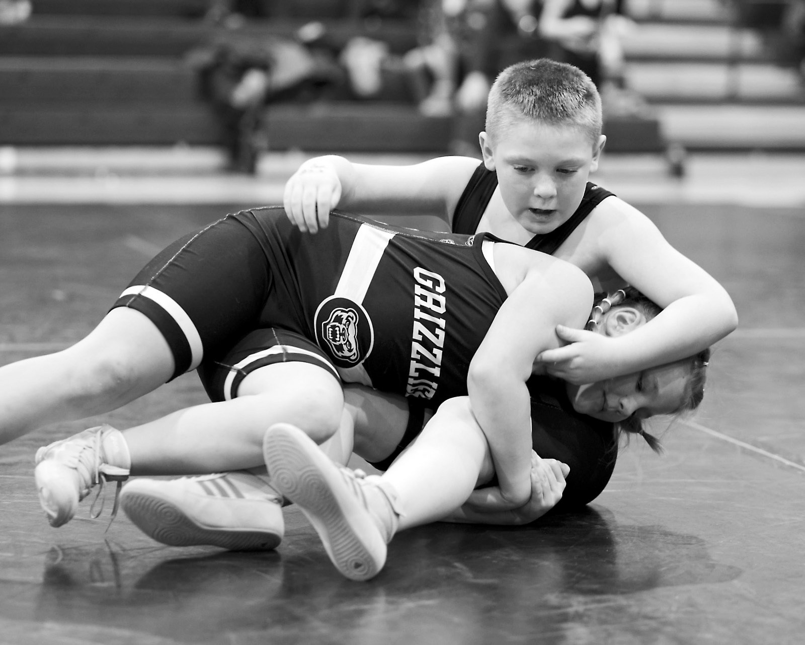 Quinn Anderson wraps her arms around McCoy Beniot and attempts to get him in a pinning position. Photo by Larry Stokke.