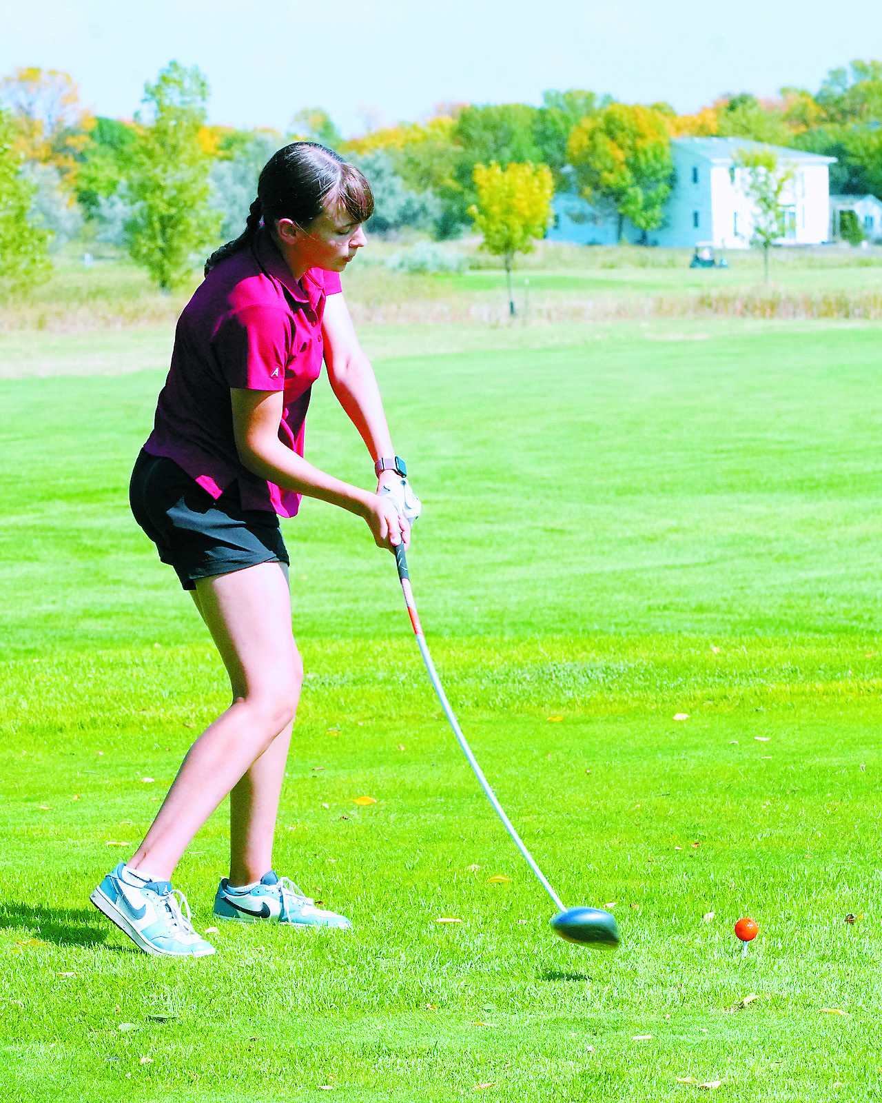 Lily Zimmer tees off putting a curve in her club at the Regional Golf Meet. Photo by Larry Stokke.