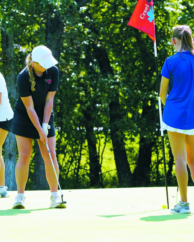 Harper Jacobson drops the ball in the cup at the Devils Lake Regional Meet on Sept. 16. Photo by Larry Stokke.