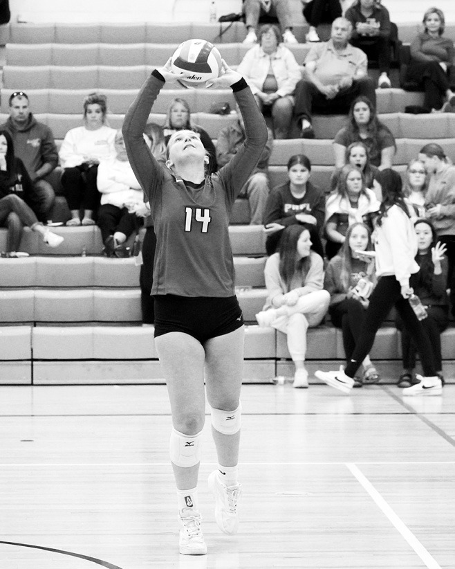 Emma Hall sets the volleyball high to a teammate. Photo by Larry Stokke.
