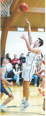 TJ Henderson drops the ball in the basket and had a 10 point game for the Cards. Photo by Larry Stokke