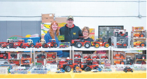 It’s a family affair at the Toy Show in Langdon: Daughter Jenny Schrader joins her parents, Mike and Connie Schrader, at their booth over the weekend after getting everything set up and ready for visitors. Photo by Larry Stokke