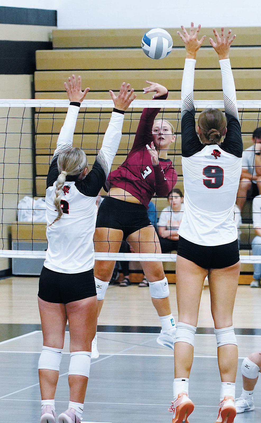 Emma Hall sends the ball between two Cavalier Tornadoes for a point. Photo by Larry Stokke.