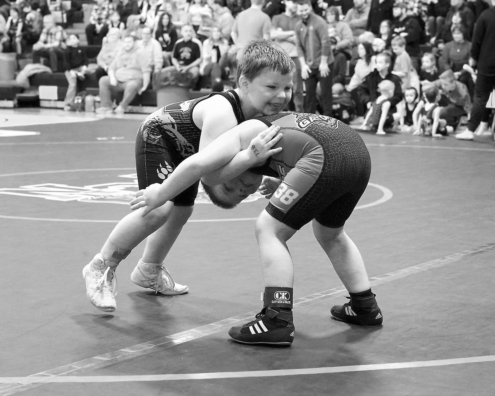 North Border Grizzle wrestler Malcolm Greenwood ties up his Gator and takes him to the mat. Photo by Larry Stokke.