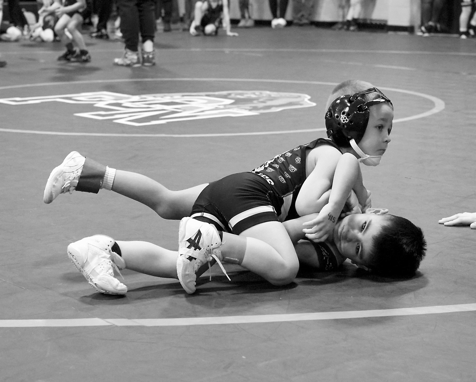 North Border wrestler Gunner McKay looks over at the referee while getting his opponent on his back for a pin. Photo by Larry Stokke.