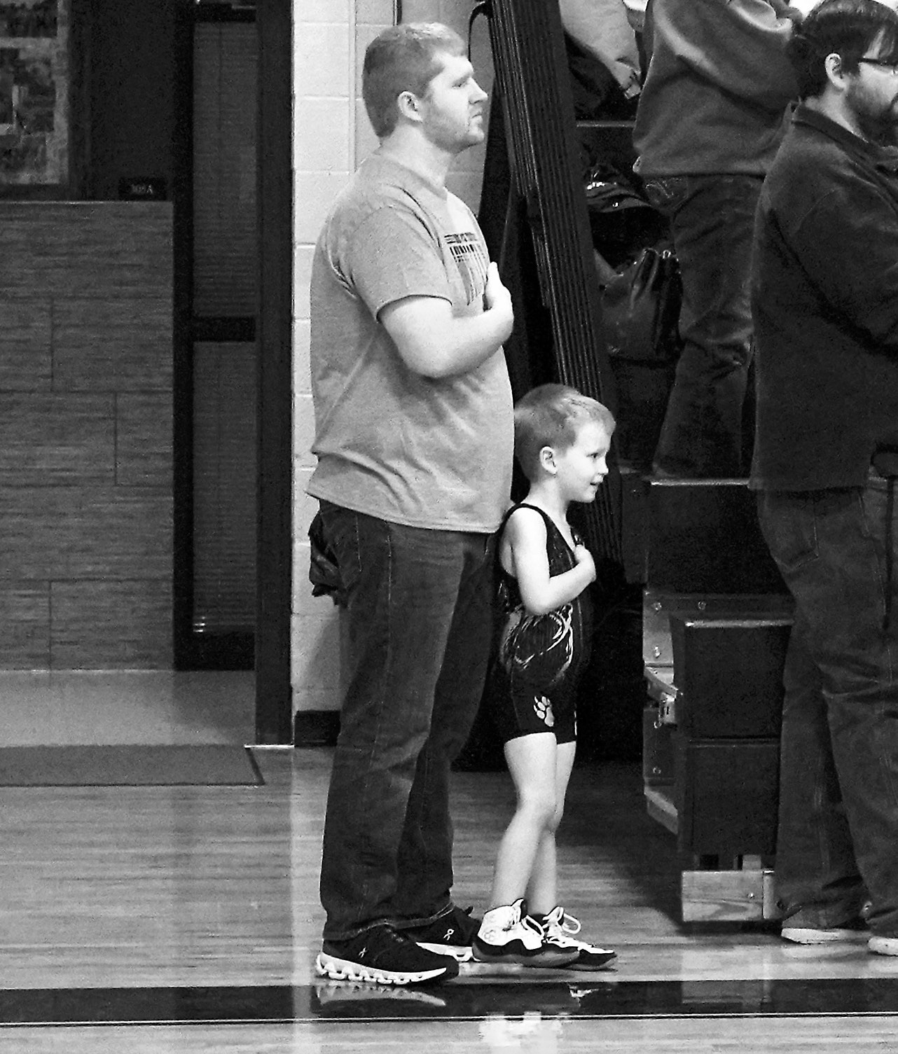 A father with his young athlete showing Patriotism to the flag at the beginning of the tournament on March 1. Photo by Larry Stokke.