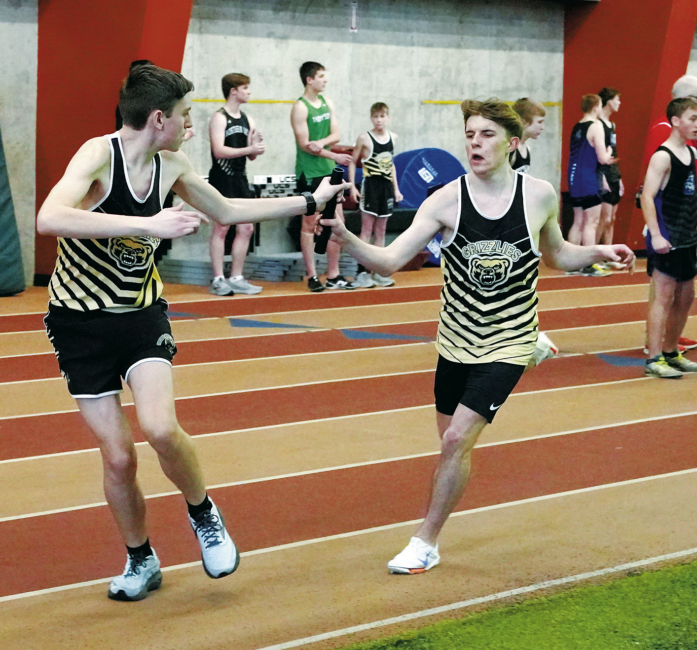 Nash Fitzsimonds hands off the baton to Connor O'Hara who, along with teammates Sawyer Girodat and Jaxon Suedel, placed 4th in the 4x600 relay. Photo by Larry Stokke.