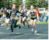 Mia Seng hands the baton to Gracelynn during relay action at the meet in Larimore. Photo by Larry Stokke.