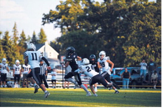 North Border’s Rhyder Girodat, No. 6, fights through a tackle during the Eagles’ season opener against the North Prairie Cougars on Friday, Aug. 21, in Pembina. Photo by Ashley Schafer