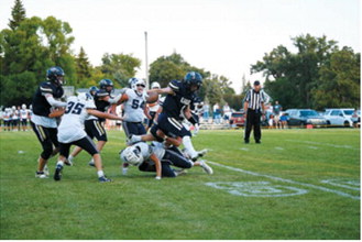 North Border’s Zeke Symington, No. 1, battles through a pair of North Prairie defenders on Friday, Aug. 21. Photo by Ashley Schafer